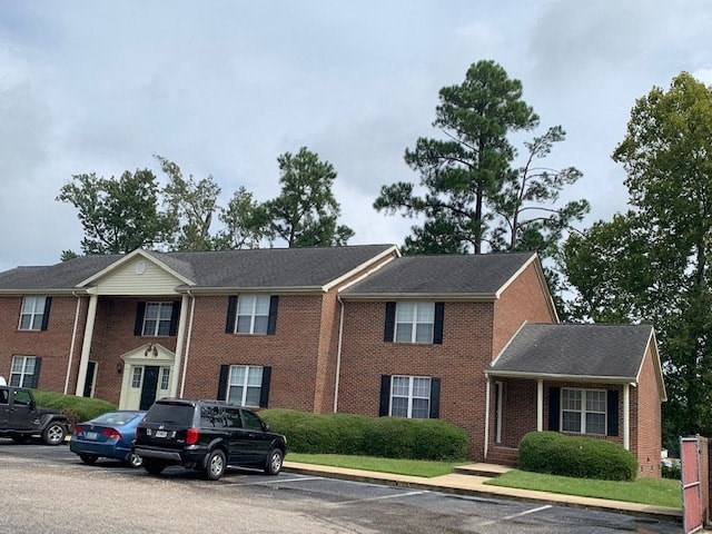 a brick house with cars parked in front of it