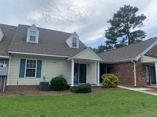 a white house with a grass yard and a brick house