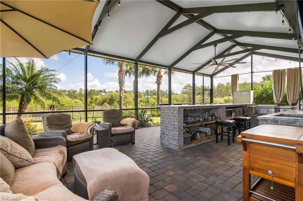 a living room with couches and a bar in a screened in porch