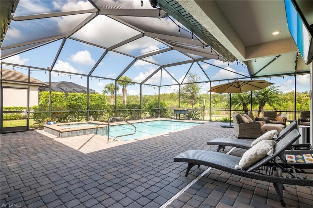 a swimming pool and patio with chairs and umbrellas