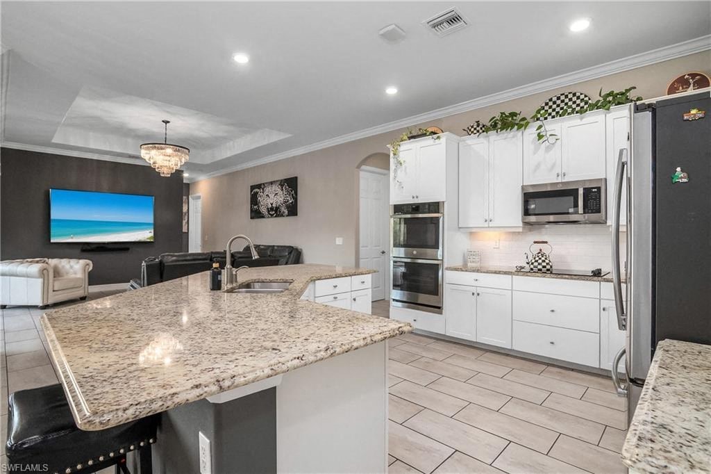a kitchen with white cabinets and a marble counter top