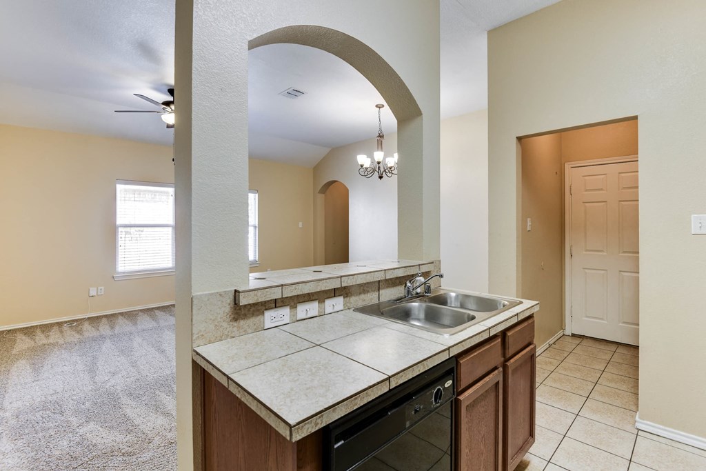 an empty kitchen with a sink and a mirror