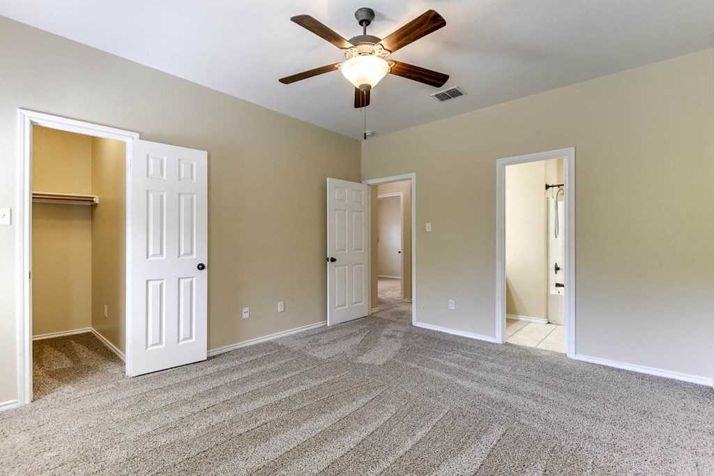 an empty living room with a ceiling fan