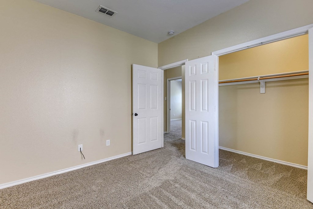 a bedroom with a closet and a door to a hallway