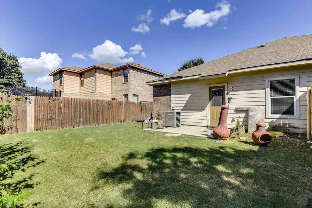 the backyard of a house with a yard and a fence