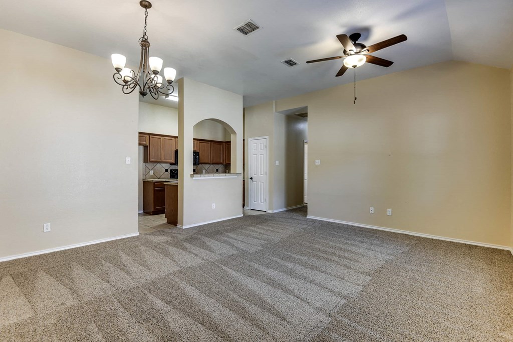 a living room with carpet and a ceiling fan