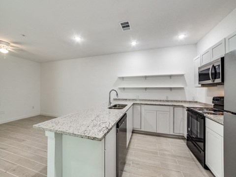 the kitchen of our studio apartment atrium with granite counter tops and black appliances