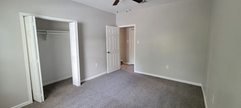 an empty bedroom with a closet and a door to the bathroom