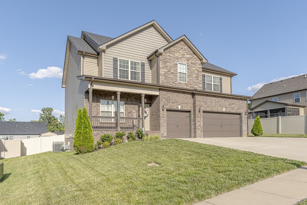 the front of a house with two garage doors and a lawn
