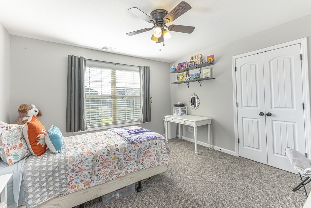 a bedroom with a bed and a ceiling fan