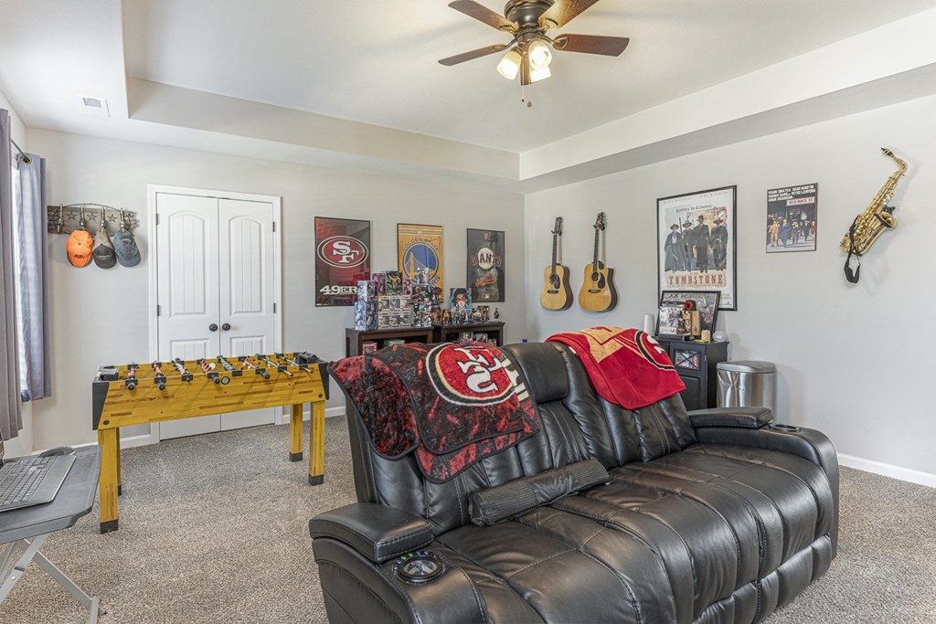 the living room has a leather couch and a foosball table