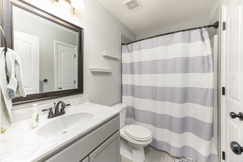 a bathroom with a shower and a sink and a toilet