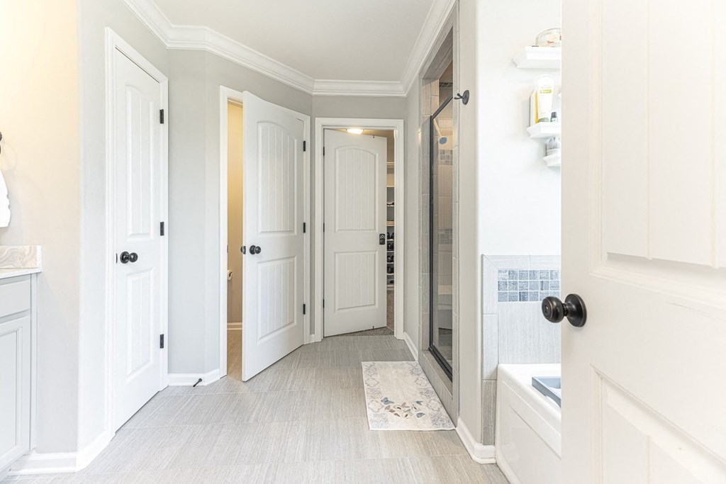 a renovated bathroom with white doors and a walk in shower