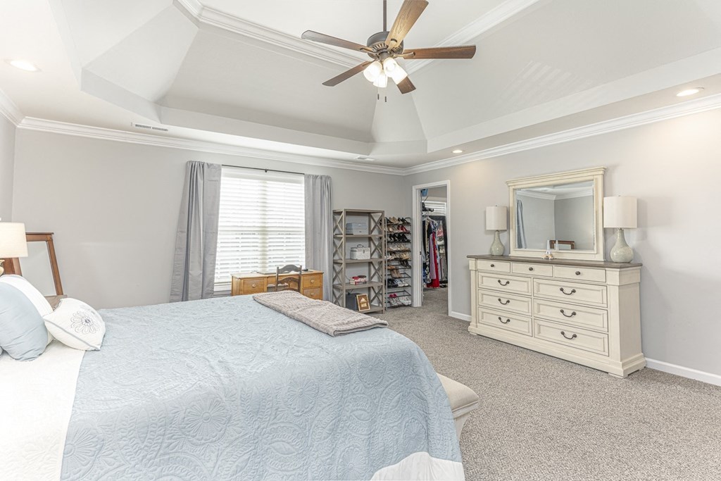 a bedroom with a large bed and a ceiling fan