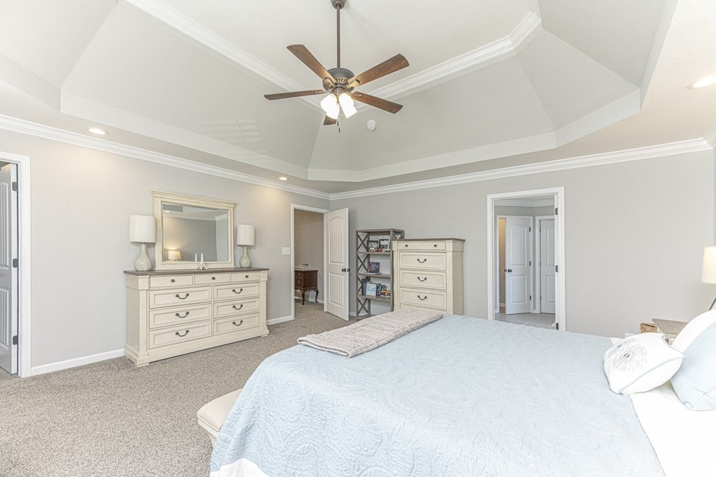 a bedroom with a large bed and a ceiling fan