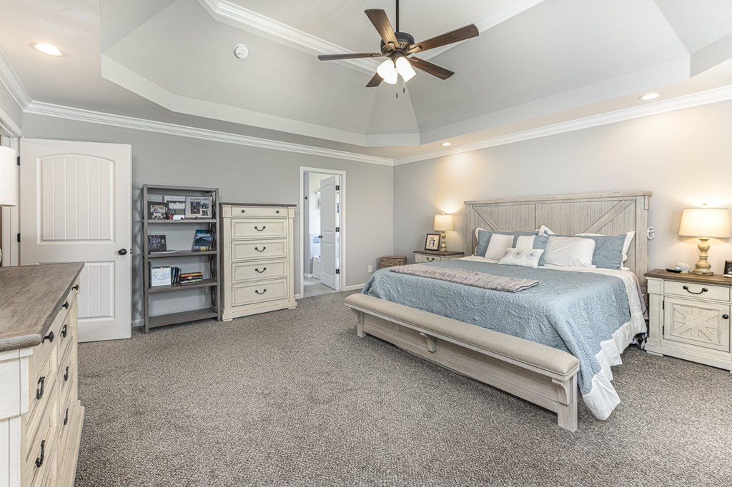 a large bedroom with a bed and a ceiling fan