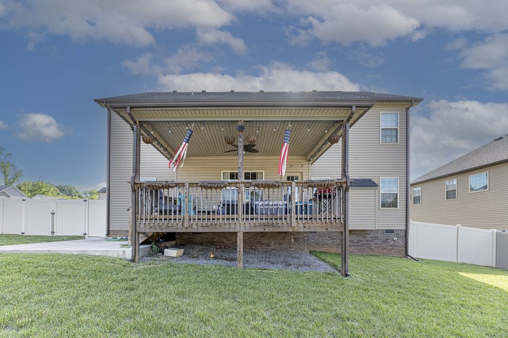 the backyard has a deck with a grill and flags