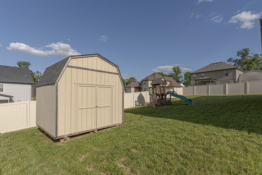 a shed in a backyard with a playground