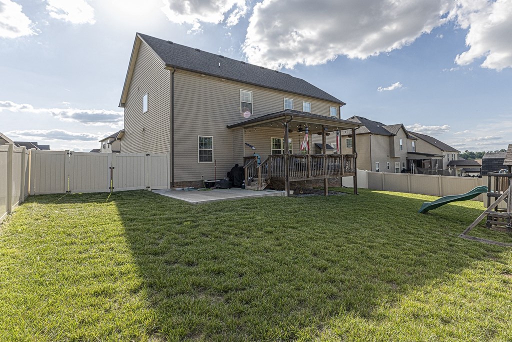 a backyard with a patio and a house with a deck