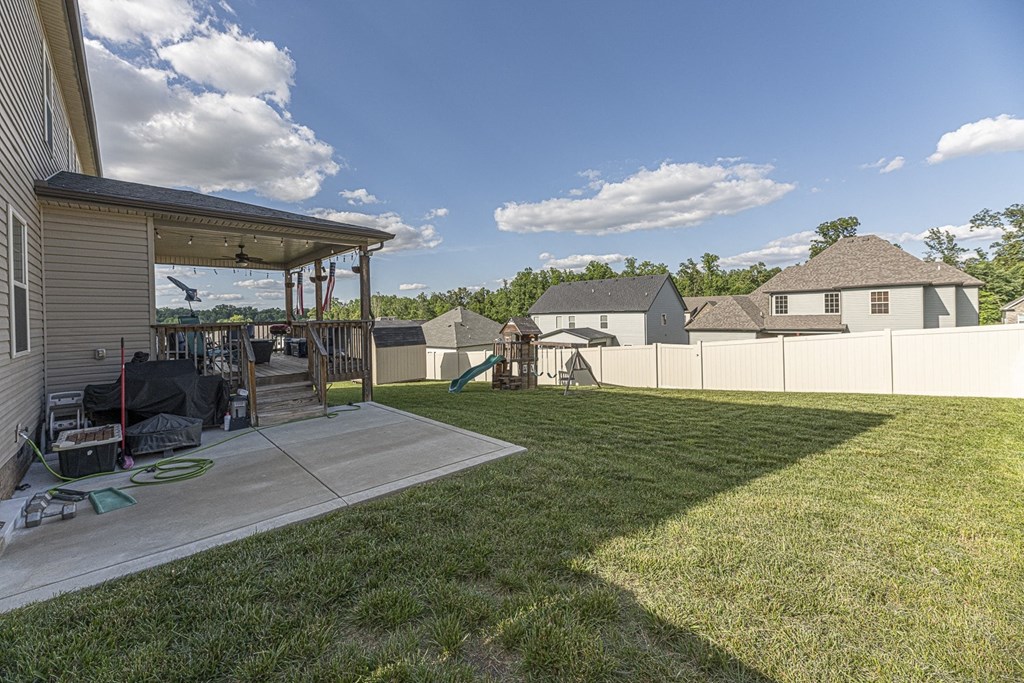 a backyard with a patio and a fence and a house