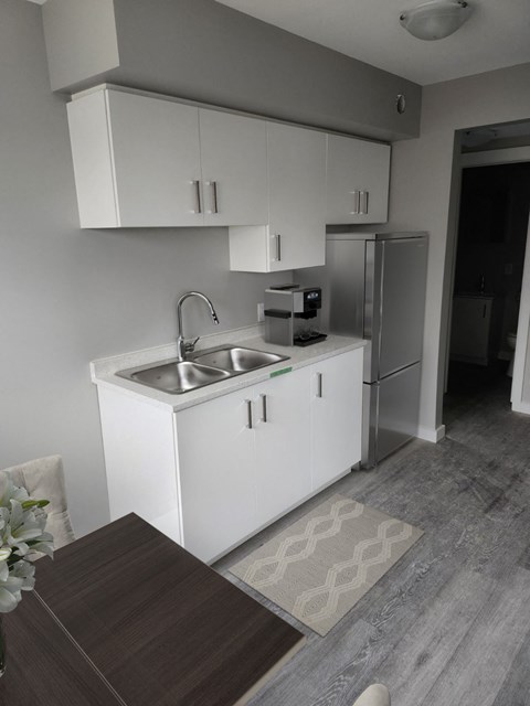 A kitchen with white cabinets and a sink.