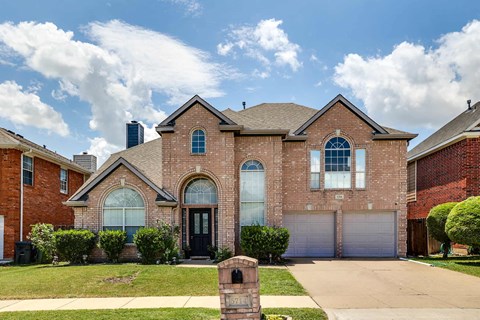 a brick house with a driveway and a garage door