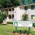 a sign in front of a house with balloons