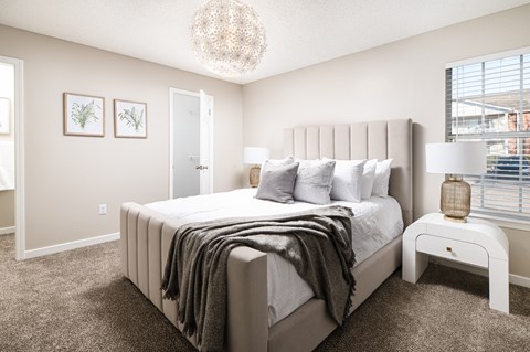 a bedroom with a large bed and a chandelier