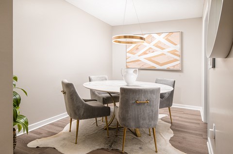 a dining room with a table and chairs and a painting on the wall
