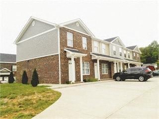 A brick building with a black car parked in front.