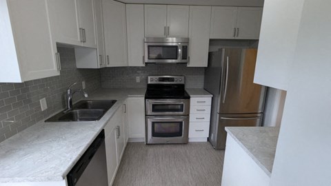a kitchen with white cabinets and stainless steel appliances