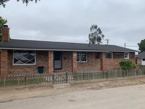 A brick house with a wooden fence in front.