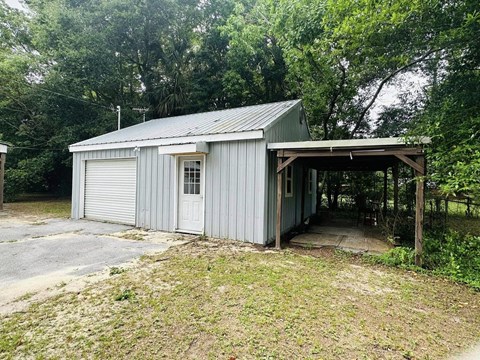 a small garage with a metal roof on a driveway