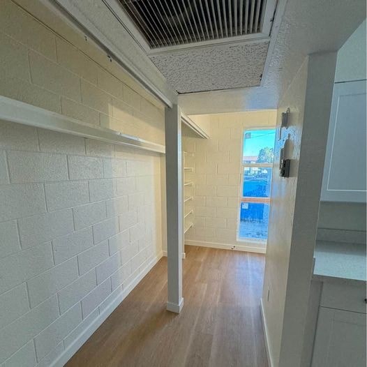 an empty room with a wood floor and white walls