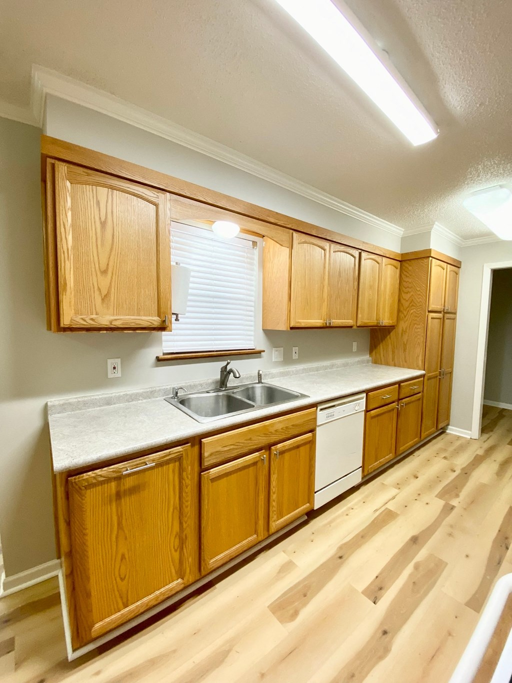 an empty kitchen with wooden cabinets and a sink