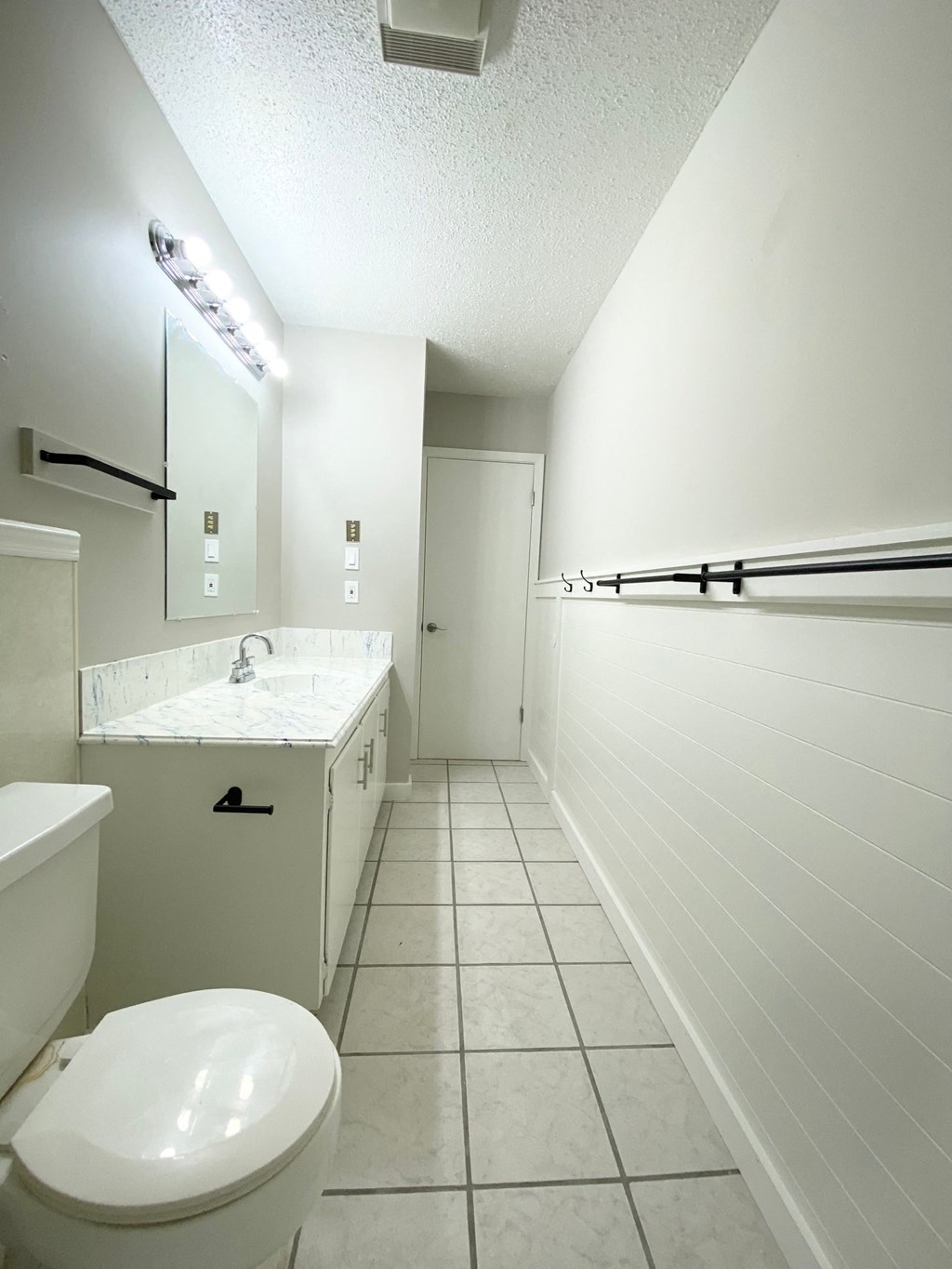 a white bathroom with a toilet and a sink