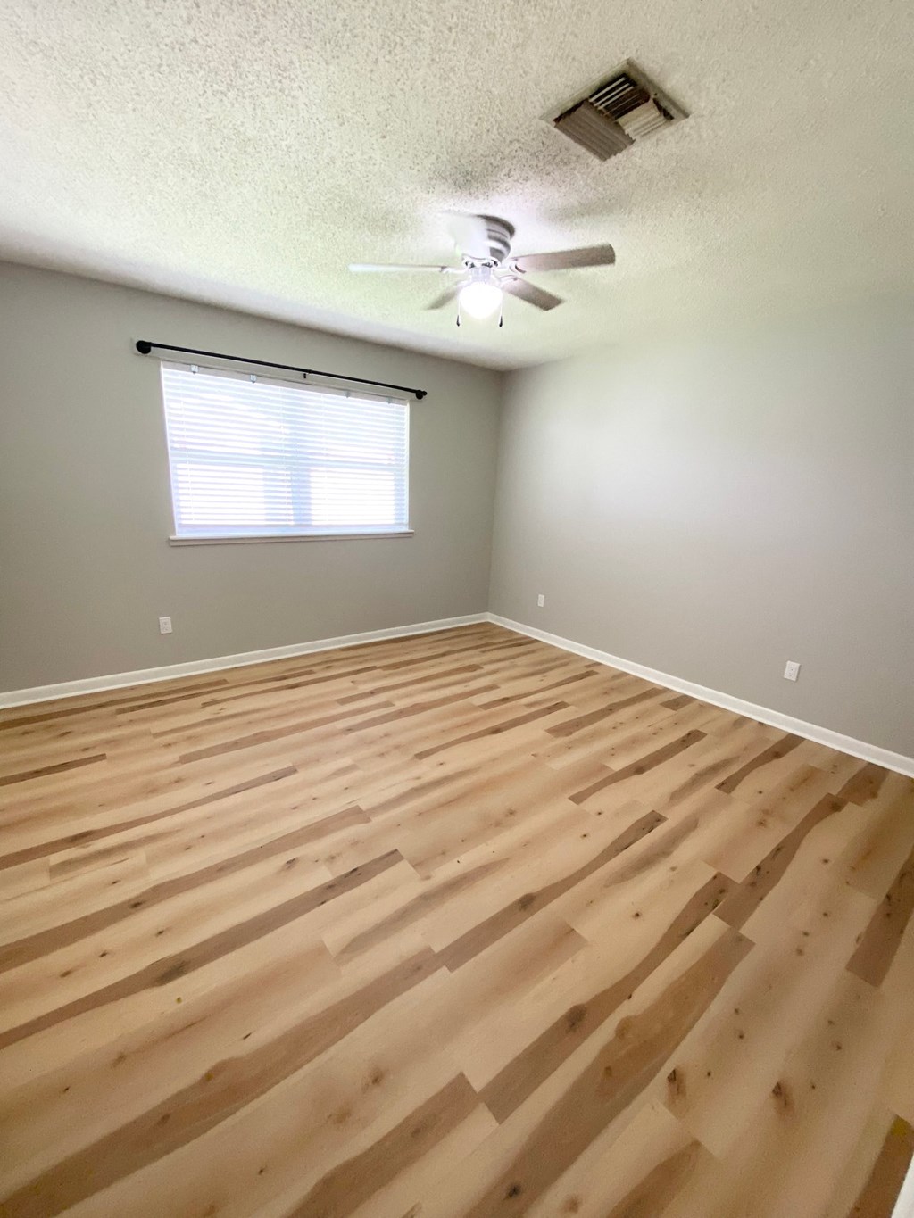 a living room with wood floors and a ceiling fan