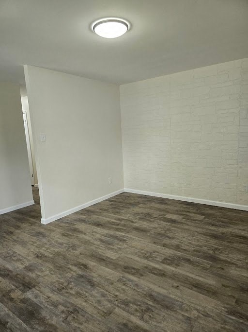 an empty living room with wood floors and white walls