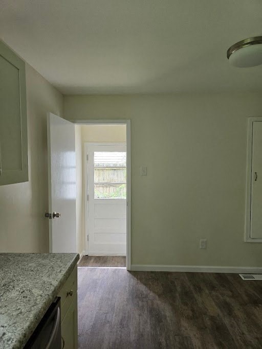 an empty kitchen with a door leading into a room
