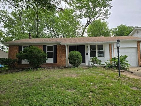 a small brick house with a yard in front of it