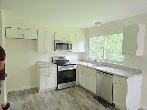 a kitchen with white cabinets and a stove and a sink