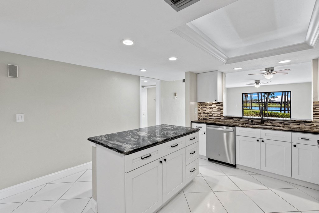 a kitchen with white cabinets and a granite counter top