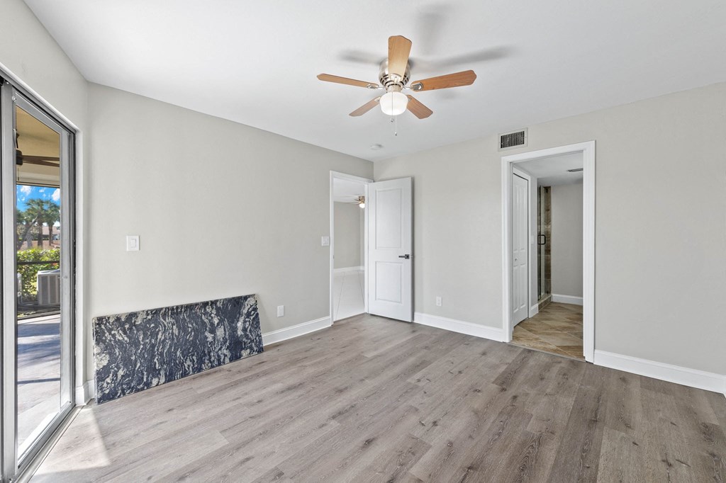 a living room with wood floors and a ceiling fan