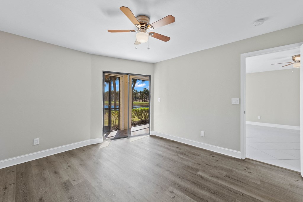 a living room with a ceiling fan and a door to a patio
