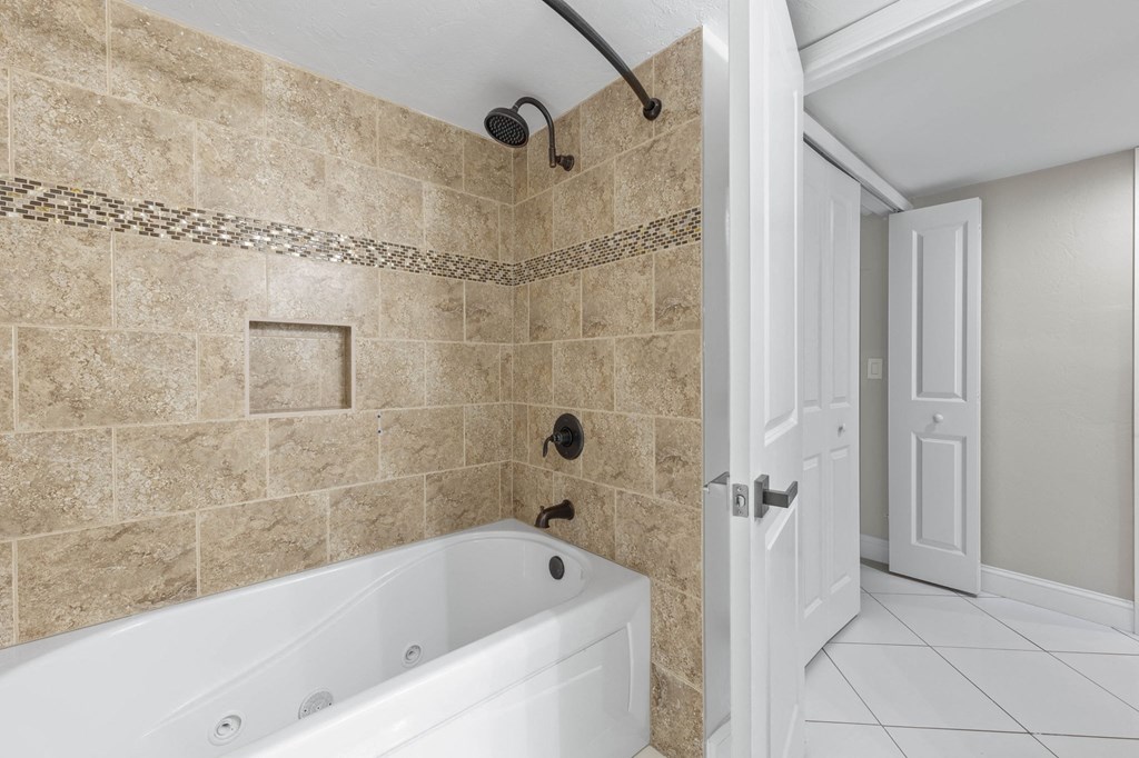 a bathroom with a tub and a shower and a door