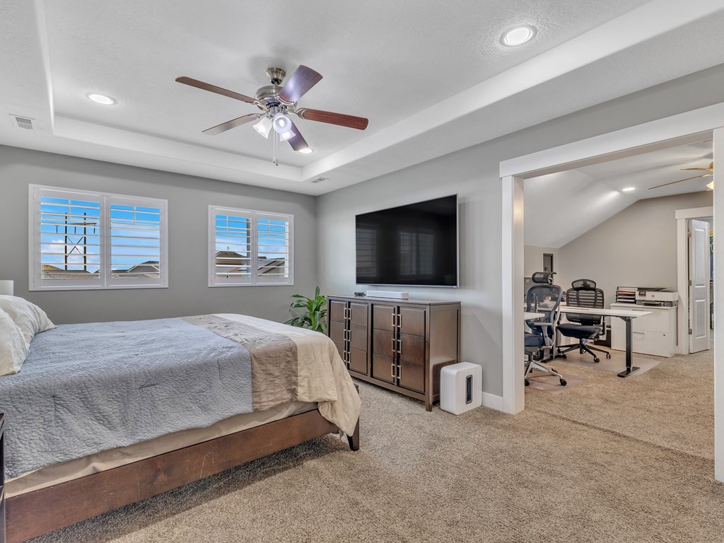 a bedroom with a bed and a ceiling fan
