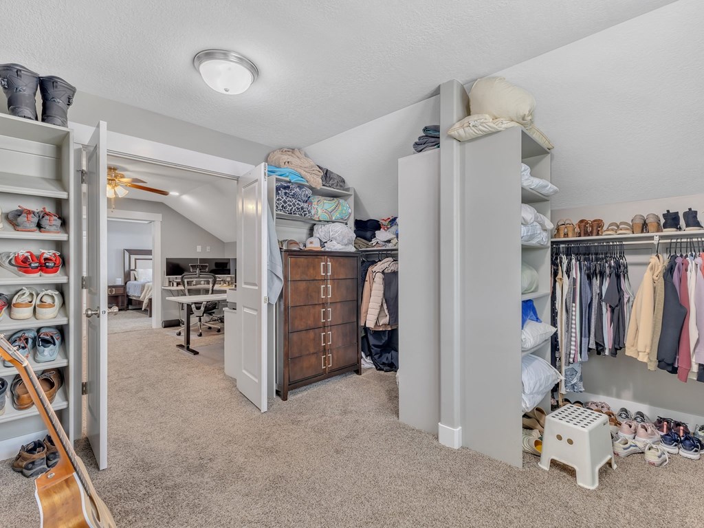 a walk in closet with a lot of closets and shelves