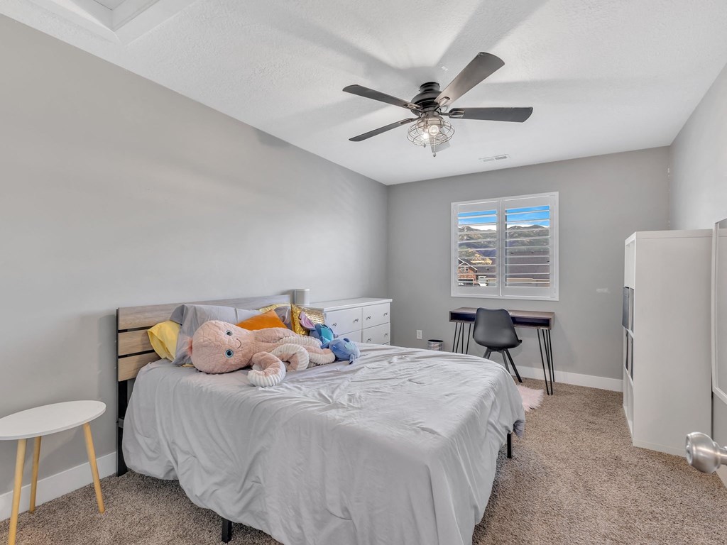 a bedroom with a bed and a ceiling fan