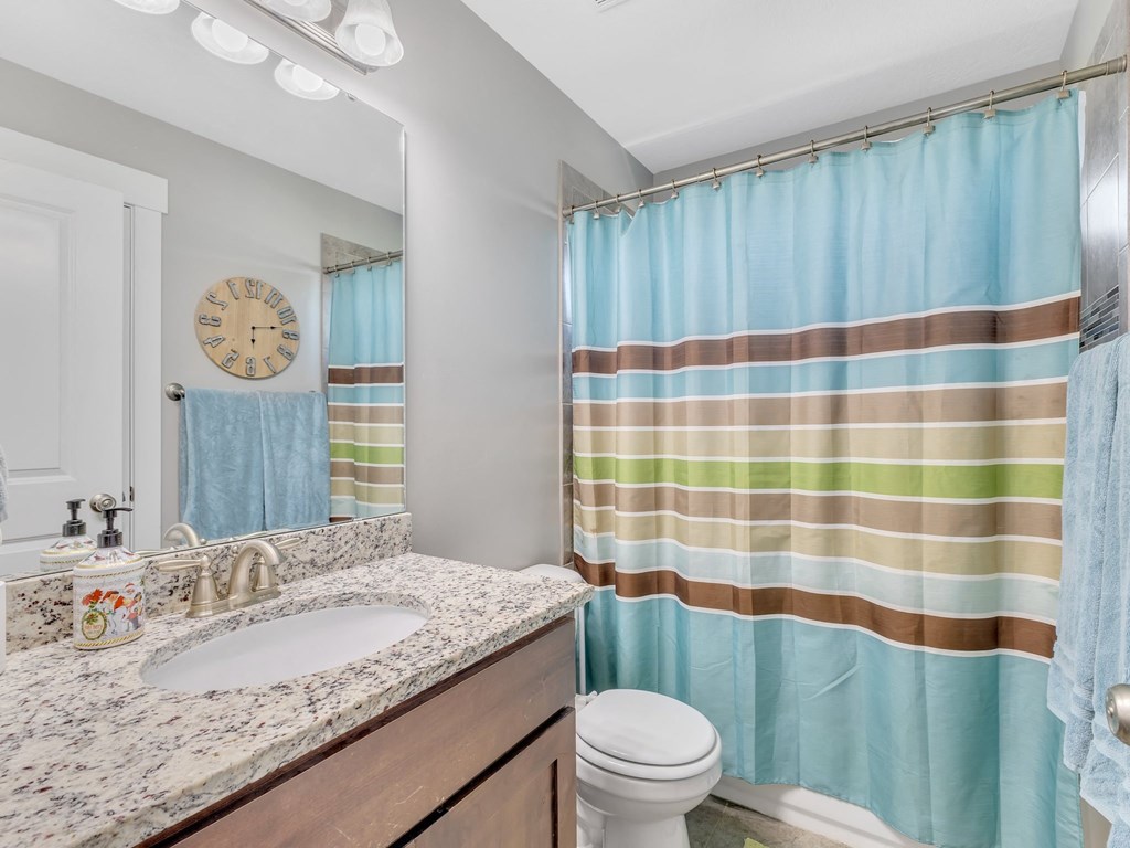 a bathroom with a shower curtain and a sink and a toilet