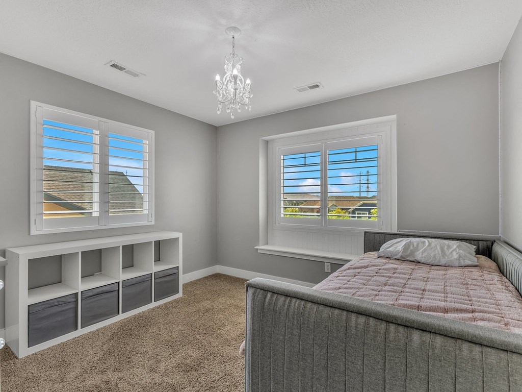 a bedroom with a bed and two windows